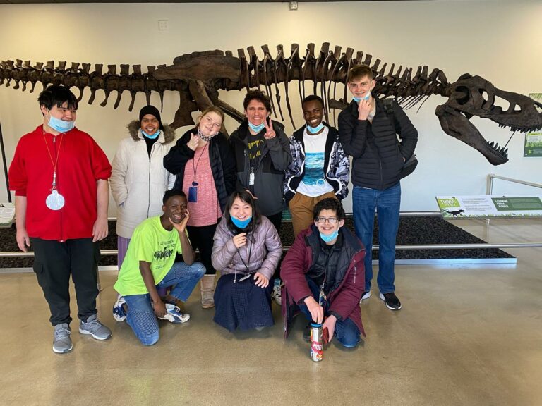 Group of people standing in front of dinosaur bones